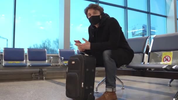 Людина в медичній масці сидить на сидінні соціальної відстані з попереджувальними знаками. Подорож на пандемію коронавірус. профілактики безпеки здоров'я . — стокове відео