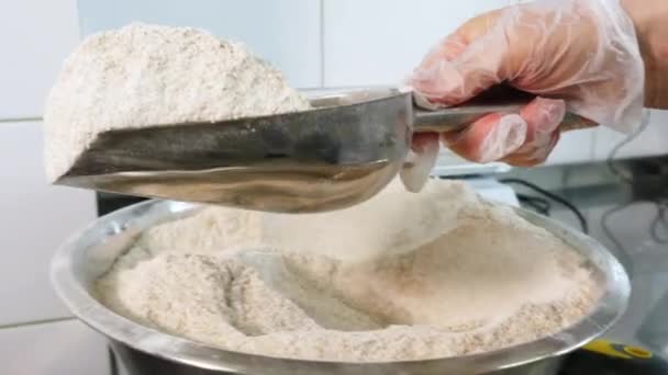 Close-up de chef derramando farinha de colher em tigela misturador elétrico. Trabalho de pastelaria. massa de farinha de amassar para pão ou massa. — Vídeo de Stock