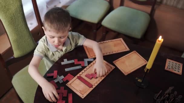 Het kind maakt een houten puzzel aan tafel. Educatief logisch speelgoed voor kinderen — Stockvideo