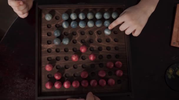 Настільна гра з червоними і синіми кульками на ігровому полі — стокове відео