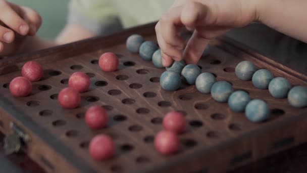 Настільна гра з червоними і синіми кульками на ігровому полі — стокове відео