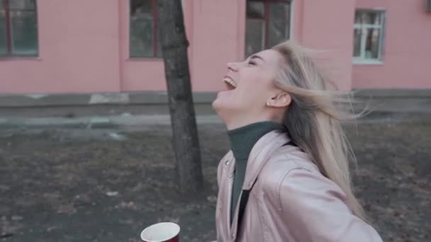 Porträtt av en tjej som skrattar roligt. Flickan går i staden, långsam skytte. — Stockvideo