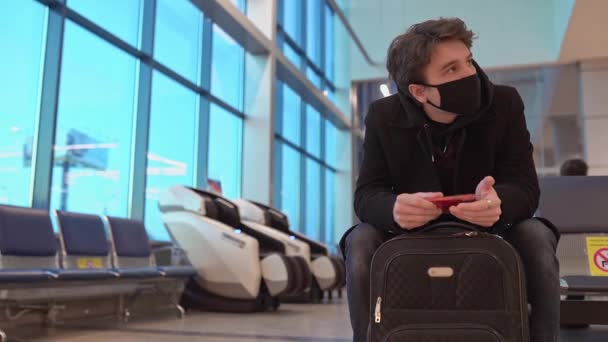 Jeune homme d'affaires en attente d'un avion de vol retardé dans la salle d'attente moderne de l'aéroport bondée de passagers. — Video
