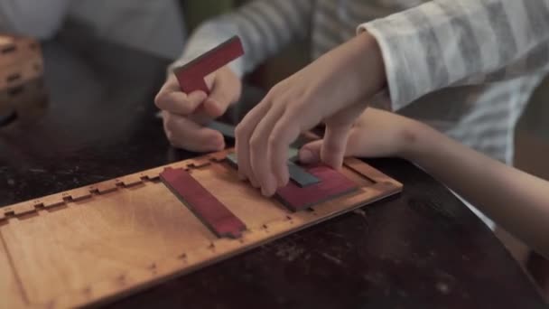 Close-up van de handen van kinderen die een gekleurde puzzel verzamelen — Stockvideo