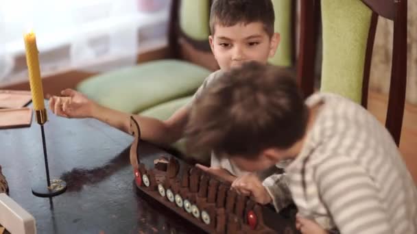 Двоє хлопців грають у стару настільну гру вікінгів. Дерев "яний корабель з війнами. — стокове відео