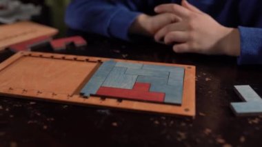 Çocuğa yakın çekim, ahşap mantıklı bir oyuncağı eller katlar. Çocuklar için eğitici mantıklı oyuncaklar. Çocuk gelişimi için Montessori oyunları