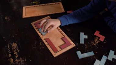 Çocuğa yakın çekim, ahşap mantıklı bir oyuncağı eller katlar. Çocuklar için eğitici mantıklı oyuncaklar. Çocuk gelişimi için Montessori oyunları