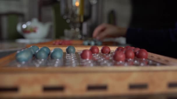 Board game with red and blue balls on the red playing field, black background — Stock Video