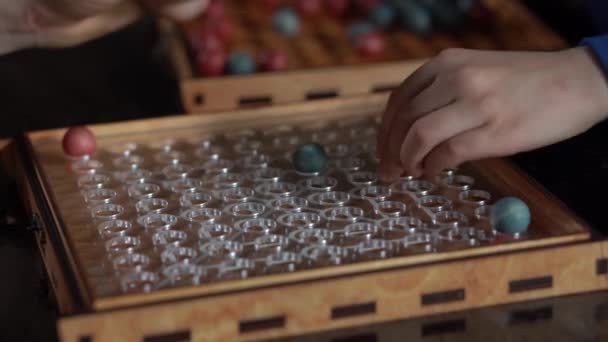 Board game with red and blue balls on the red playing field, black background — Stock Video