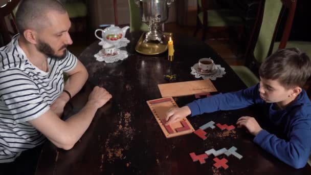 Padre y su lindo niño montando rompecabezas juntos. Padre y su pequeño niño tienen tiempo libre en casa. — Vídeos de Stock