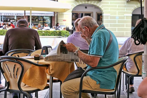 VENICE, MESTRE-June 29, 2014. Elderly man reading a newspaper in — Stock Photo, Image