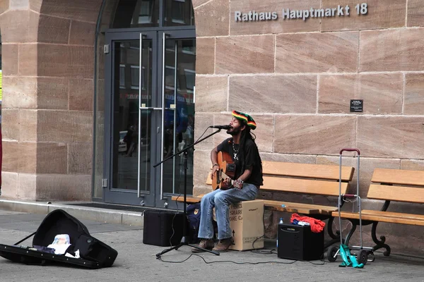 NURNBERG, ALEMANIA - 13 DE JULIO DE 2014: Hauptmarkt, la plaza central de Nuremberg - músico callejero, cantando y tocando la guitarra, tocando en las calles — Foto de Stock