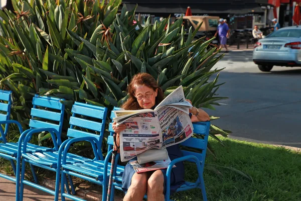 CANNES, FRANCIA - 5 LUGLIO 2014. Donna che legge un giornale sul — Foto Stock