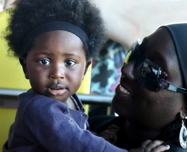 Accra, Gana - 1 Temmuz 2014. Kimliği belirsiz Ganalı küçük kız bebek anne kollarındaki. Gana halkı yoksulluk zor ekonomik durum nedeniyle acı