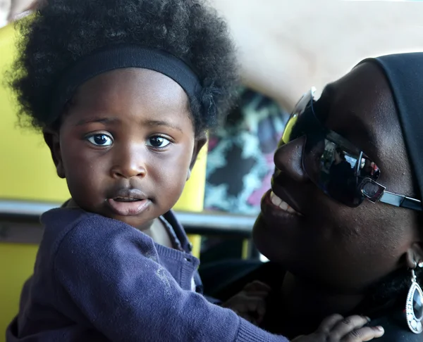 ACCRA, GHANA - July 1, 2014.  Unidentified Ghanaian little baby girl on her mother arms. People of Ghana suffer of poverty due to the difficult economic situation