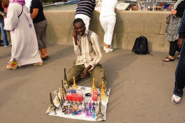 París, Francia 18 de agosto de 2014. Inmigrante africano ofreciendo recuerdos en un puente sobre el Sena. París, Francia 18 de agosto de 2014 —  Fotos de Stock