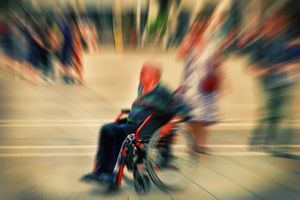 Abstracte achtergrond. Een gehandicapte persoon in een rolstoel op een stad — Stockfoto