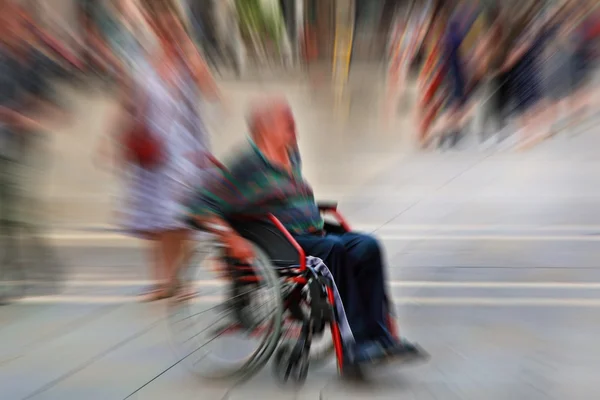 Contexte abstrait. Une personne handicapée en fauteuil roulant dans une ville — Photo