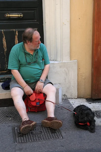 Aix-en-Provence, FRANCIA 1 LUGLIO 2014. Uomo anziano con un cane seduto sulle scale all'esterno. Aix-en-Provence fa parte del patrimonio culturale e storico della Francia. Aix-en-Provence, 1 luglio 2014 . — Foto Stock