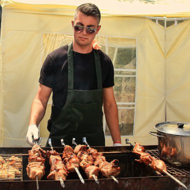Kişinev, Moldova. 23 05 2015 Barbekü Fest. Genç adam fry bir şiş ve tavuk Barbekü açık havada.