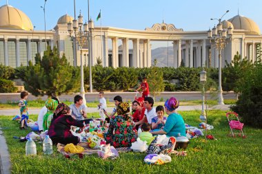 Ashgabad, Turkmenistan - August 1, 2014. Happy big family picnic clipart