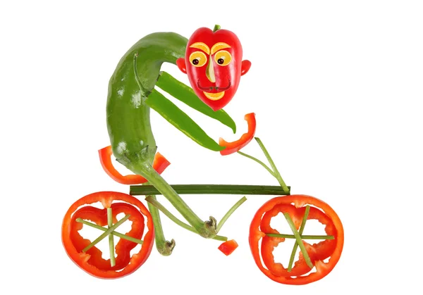 Alimentação saudável. Pequena pimenta engraçada em uma bicicleta — Fotografia de Stock