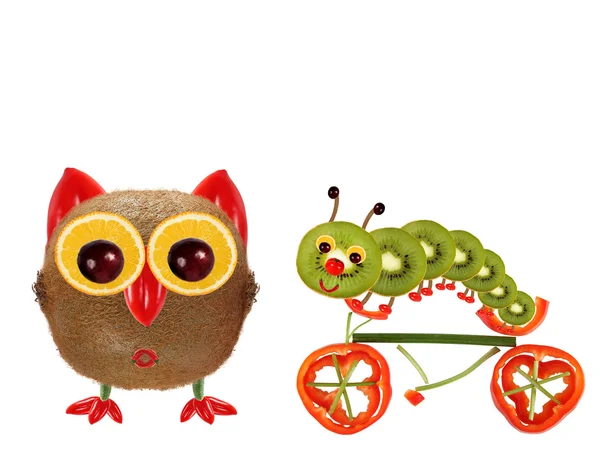 The little owl and a caterpillar on a bicycle made from vegetabl — Zdjęcie stockowe