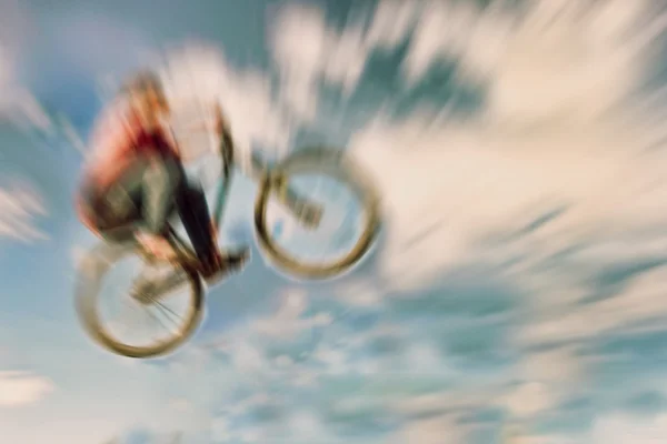 Abstract background. Boy on a BMX mountain bike jumping. Motion — Stock Photo, Image