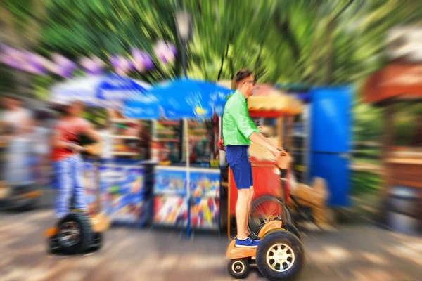 Abstract background. A young man riding a Segway in the park.  B — Stock Photo, Image