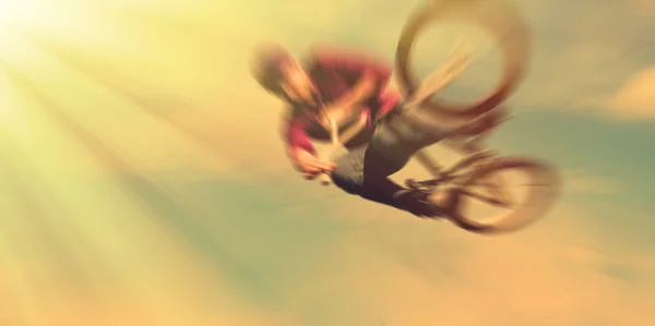 Abstract background.  Boy on a BMX mountain bike jumping. Motion — Stock Photo, Image