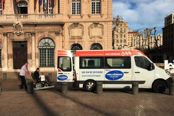 Chauffeur aidant l'homme en fauteuil roulant à entrer dans les transports municipaux — Photo