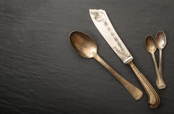 an Old silver cutlery broken on dark background