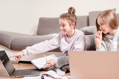 İki kız uzaktan öğrenme ile meşgul. Evde eğitim.