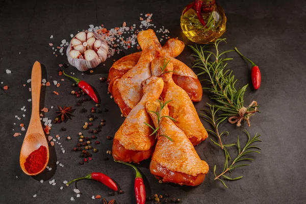 Kırmızı biberiye, biberiye ve baharatlı koyu bir arka planda tavuk budu. Tavuk budu..