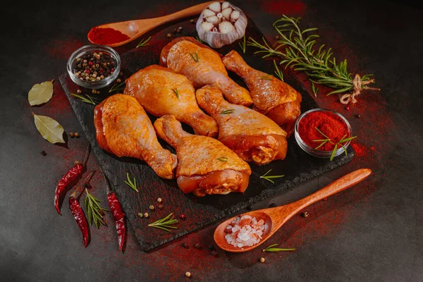 Tavuk budu, ahşap kaşıklarla siyah bir arka planda, tabakta marine edilmiş.