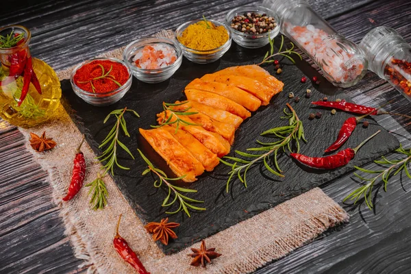 Fresh chicken meat.Marinated chicken fillet on a kitchen board with spices, garlic, red hot pepper.