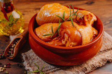 Ahşap arka planda baharatlı marine edilmiş tavuk eti. Fırında marine edilmiş tavuk budu..