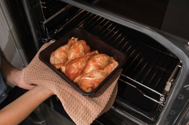 Ahşap arka planda baharatlı marine edilmiş tavuk eti. Izgarada tavuk budu. Fırın kabında marine edilmiş tavuk budu..