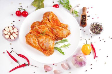 Çiğ salamura edilmiş tavuk butları ızgara ve barbekü için. Pişmemiş terbiye edilmemiş tavuk bacakları beyaz tabakta ve beyaz tabakta. Tavuk bacağı. Diyet yemek..