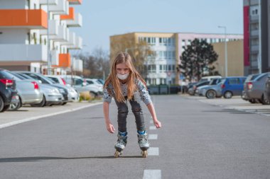 Yüzündeki yaşlılıktan koruyucu maske. Yüzüne koruyucu maske takmış patenci bir kız sokakta kayıyor..
