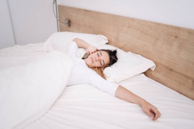 Gözlerini kapalı tutuyor ve tatmin olmuş görünüyor. Sabahları modern bir dairede güzel bir genç kızın portresi yatakta duruyor..