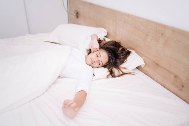 Gözlerini kapalı tutuyor ve tatmin olmuş görünüyor. Sabahları modern bir dairede güzel bir genç kızın portresi yatakta duruyor..