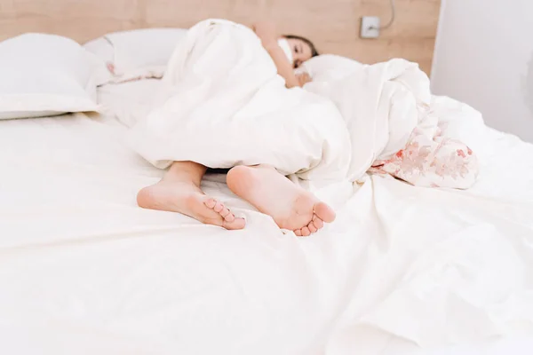 Morning, waking up on a day off, resting in bed.The girl in the morning after waking up in bed in an embrace with a pillow does not want to get out of bed.