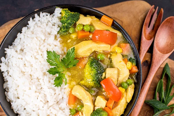 White rice with chicken and vegetables and curry sauce. Indian dish rice with vegetables and chicken.tasty fillet chicken curry with rice on a plate on the table.