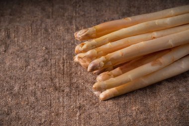 Kumaş arka planda çiğ organik beyaz kuşkonmazın yakın çekimi. Organik beyaz kuşkonmaz..