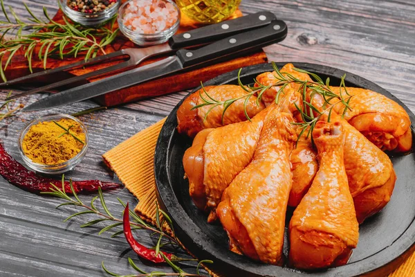 Top view.Convenience food,pree cookedMarinated Chicken Drumstick on Black Ceramic Round Roasting Plate Raw Chicken for Grilling with Spices for Cooking.
