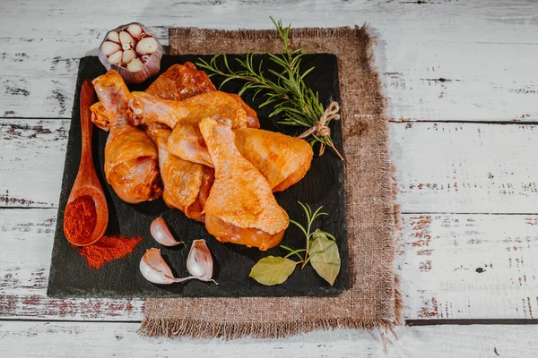 トップ表示 便利な食べ物 無料の調理された黒のセラミックプレート上にマリネチキンドラムスティック 調理用スパイスで焼くための生鶏 — ストック写真