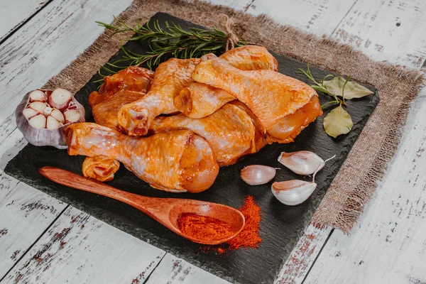 Top view.Convenience food,pree cookedMarinated chicken dramstick on a black ceramic plate. Raw chicken for grilling with spices for cooking.