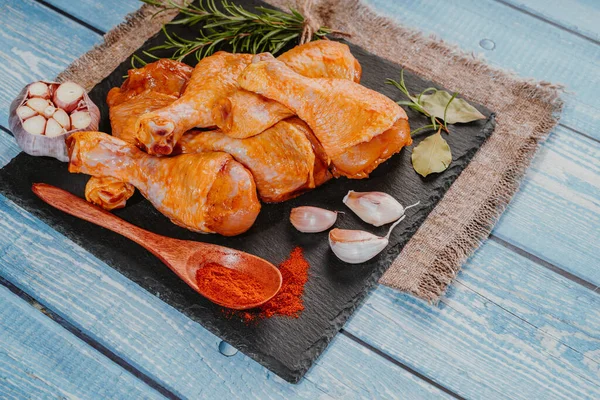 Top view.Convenience food,pree cookedMarinated chicken dramstick on a black ceramic plate. Raw chicken for grilling with spices for cooking.