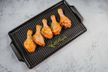 Tavada salamura edilmiş tavuk çubuğu. Manzarası çok güzel. Özel yemek, pişmiş. Pişirmek için baharatlı çiğ tavuk..